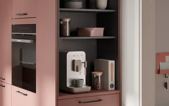 Detailansicht einer modernen Küche mit eingebauter Kaffeemaschine, Glasbehälter mit Kaffeebohnen und Deko. Warmes Farbkonzept in Rosé-Tönen mit eleganten Griffen und harmonischem Küchendesign.